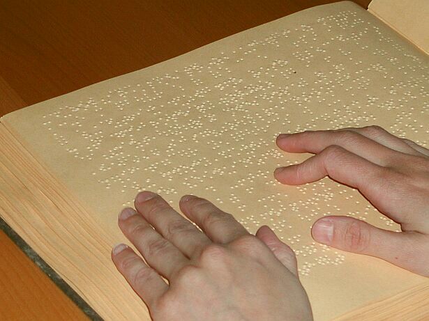 Bild vom Lesen in einem Braillebuch